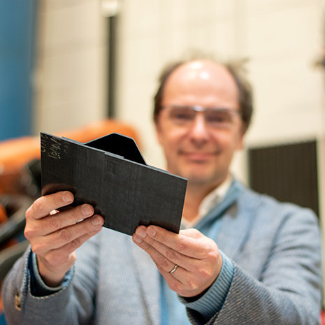 professor holds a composite material close to the camera