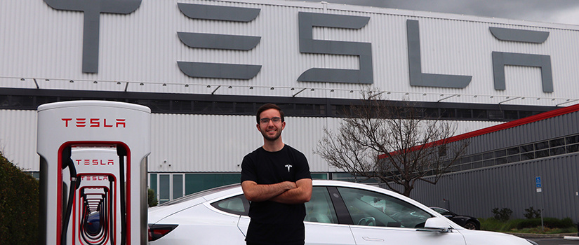 Brian stands in front of Tesla building.