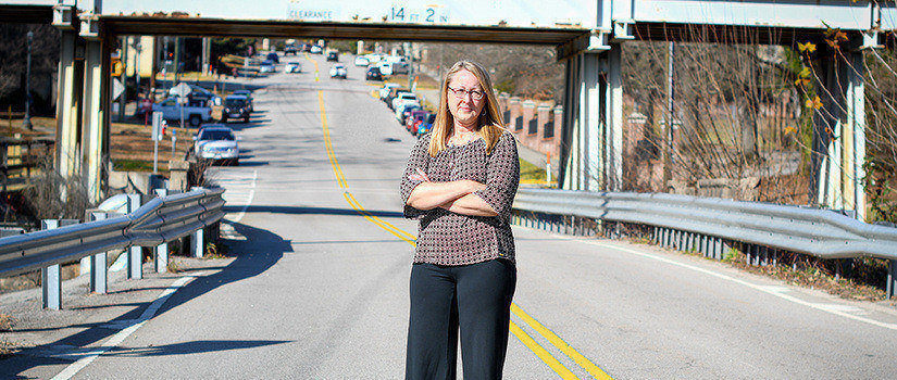 Sarah Gassman stands in the middle of an empty road.