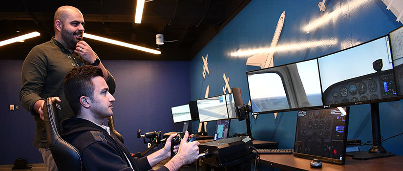 Instructor Mostafa Mobli with student in flight simulator
