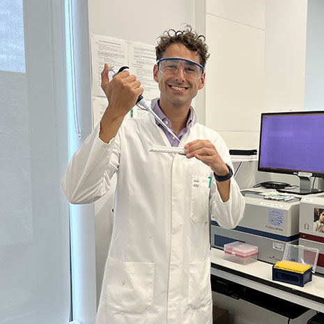 Ryan Geiser holding pipette in lab