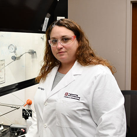 Jennifer Naglic wearing labcoat in lab