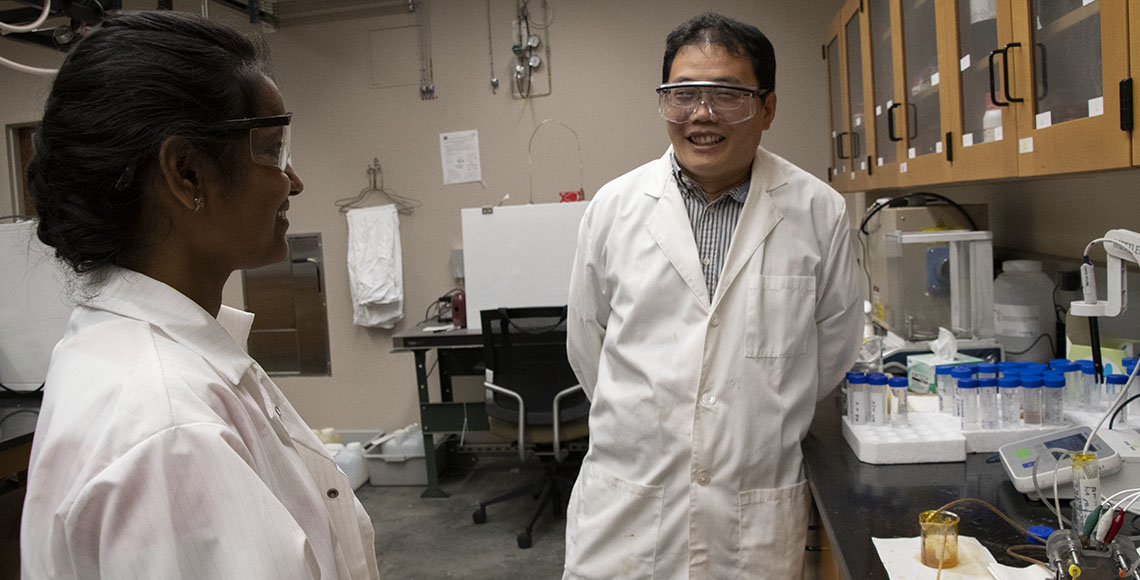 Chemical Engineering Professor Zhenmeng Peng in the lab with a graduate student