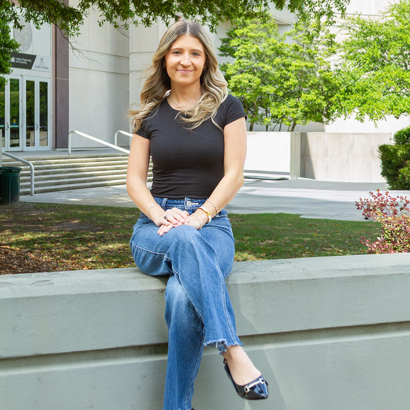 Caitlin Croci sitting in front of the Swearingen entrance. 