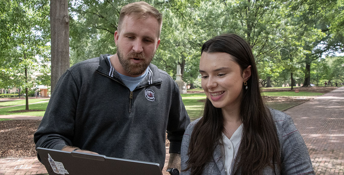Grace Cosby (pictured left) demonstrates an AI tool to a fellow USC student. 