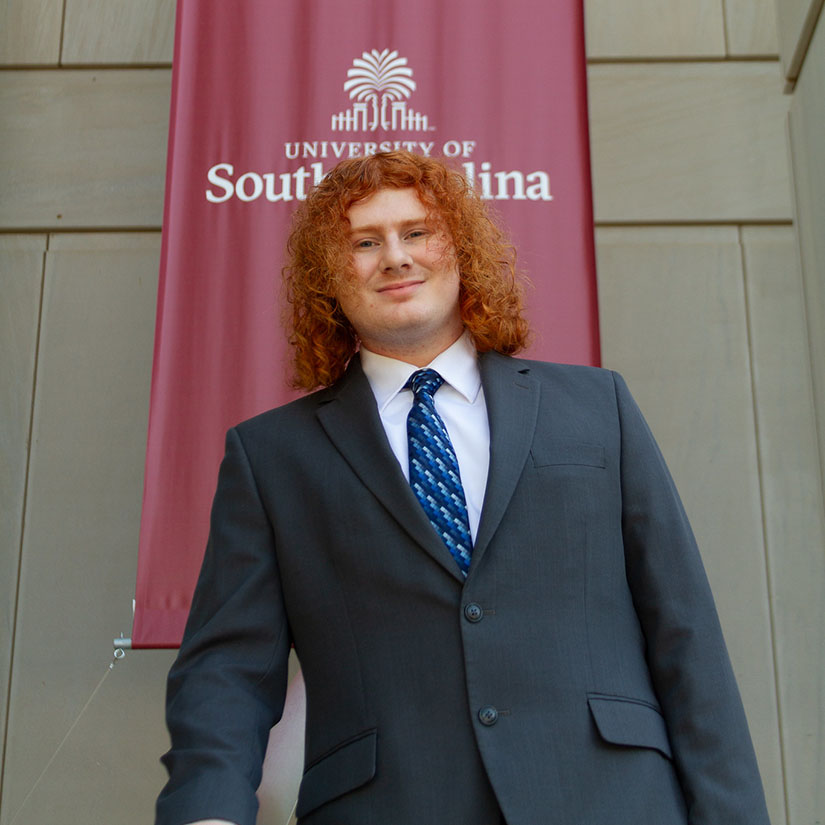 Grant Stanton in front of a USC banner.
