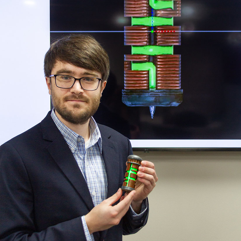 Lewis Davies holding a mechanical engineering device. 