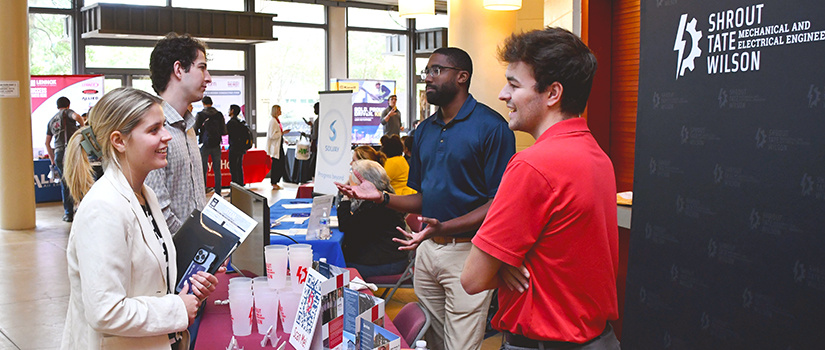 Students talk to potential employers from across display table