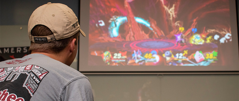 a student plays smash brothers on a projector screen