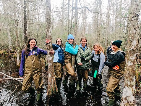 A group shot of the Semester at the Coast cohort wading through the lowcountry swamps.