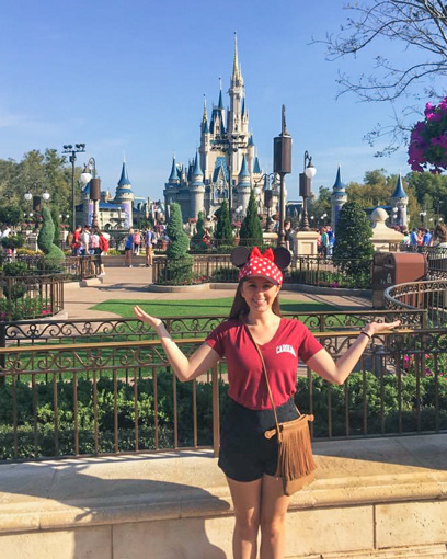 Kerry Moore in a USC shirt with Disney castles in the background.