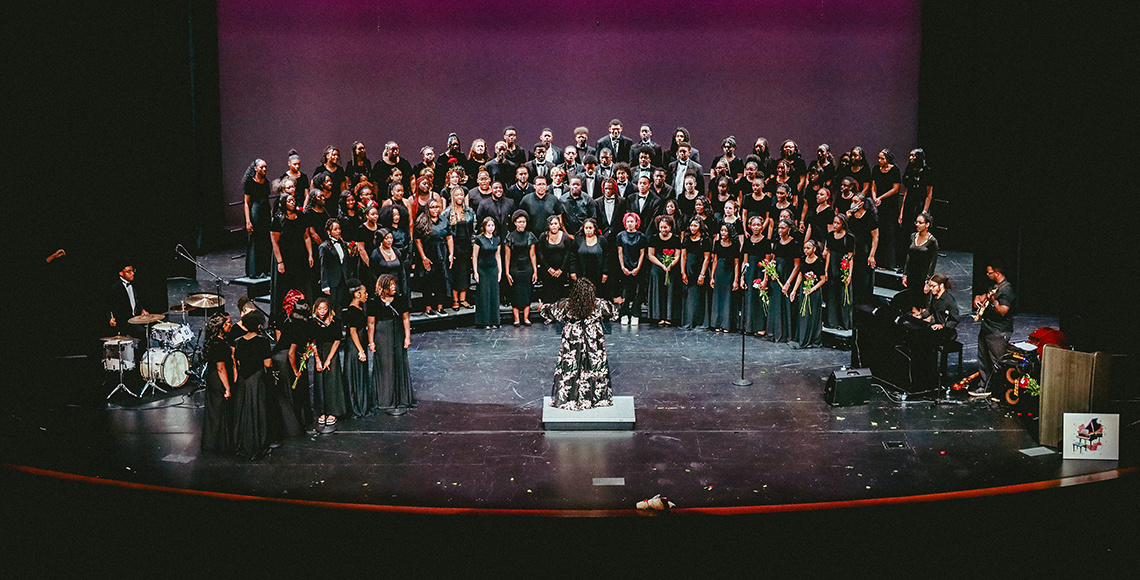 Woman conducting large musical performance.