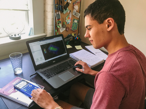 Christopher Carter working on his computer as a student.