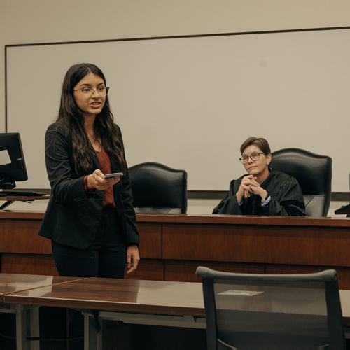 Student giving presentation in a courtroom style classroom