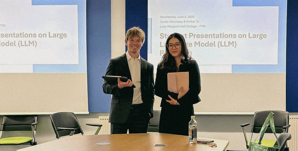 Carter Mulchaey and Amber Tu standing in front of projection screens,