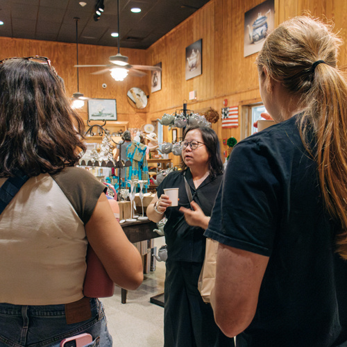 Professor holding cup of tea surrounded by students