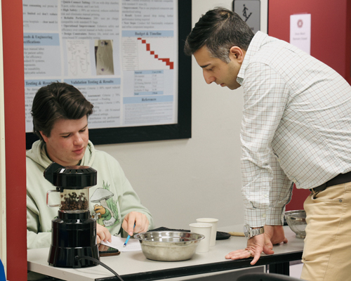 instructor Zare observing a student work.