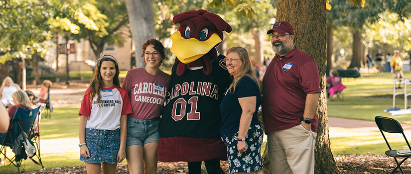 Family posing with USC's mascot Cocky on USC's historic Horseshoe.