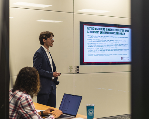 Jake Arcement presenting his research at the 2026 Honors Thesis Symposium.