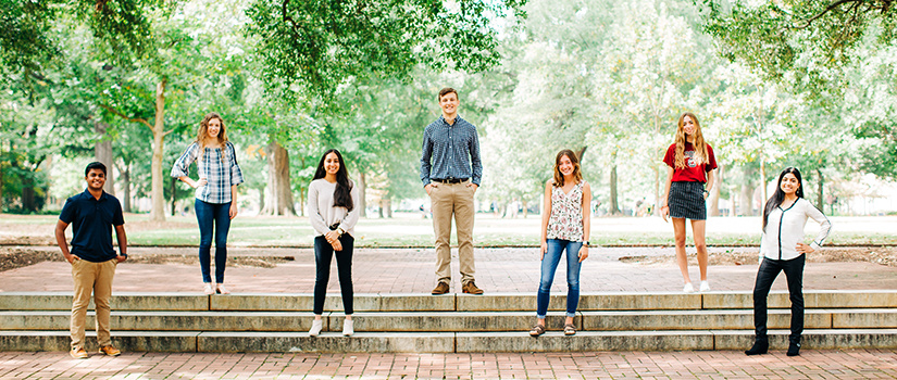 A group of cohorts standing on the Horseshoe wearing masks.