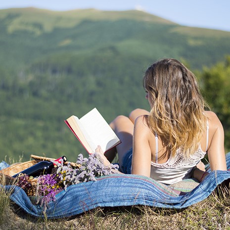 student living the good life on a blanket in a field on a mountain