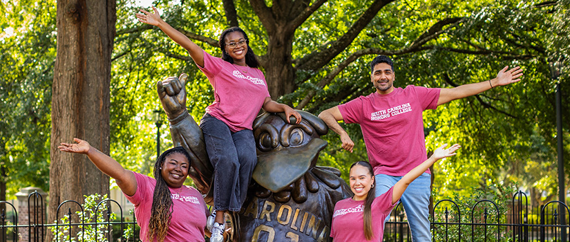Group photo of the Experience Coordinators posing by a statue of Cocky