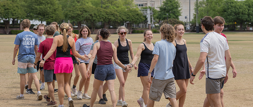 Group of Top Scholars shaking each other's hands after a game at their first-year retreat.