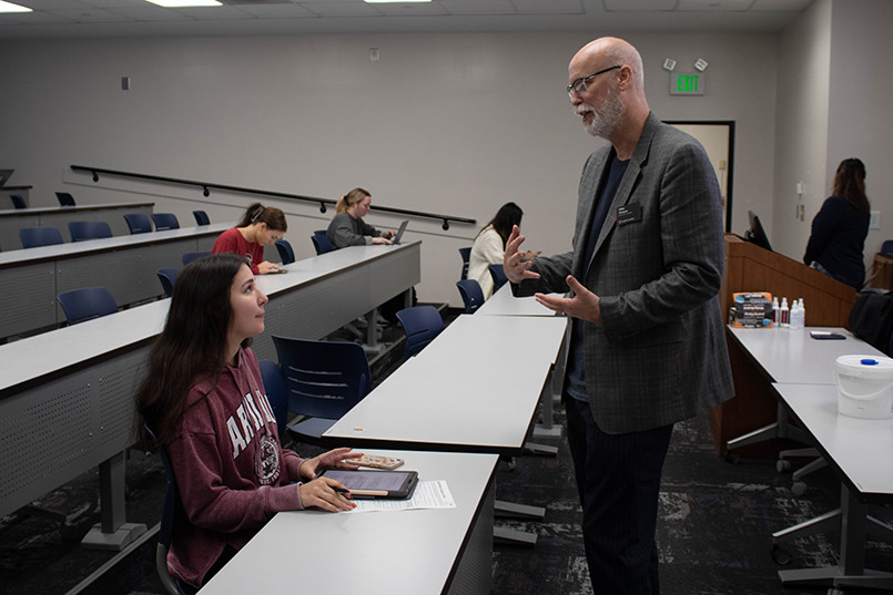 Retailing instructor Mike Watson speaks with a student during one of his classes.