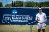 Brian Dardis stands beside the NCAA 2021 Division I Outdoor Track and Field Championships banner.