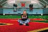 Madelin McLean, sits on the turf inside the University of Maryland's football training facility.