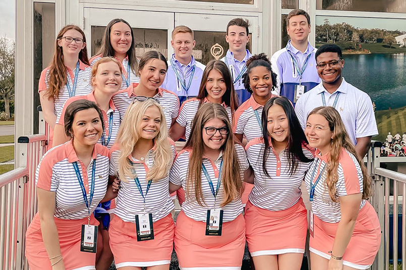 Fifteen students stand together for a photo at The Players Championship.