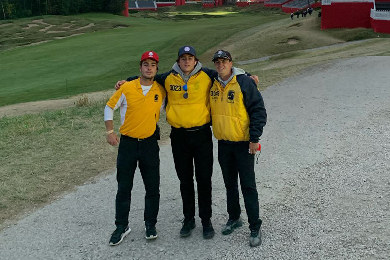 Three students working the Ryder Cup in September 2021 pose for a photo together at Whistling Straits in Haven, Wisconsin.