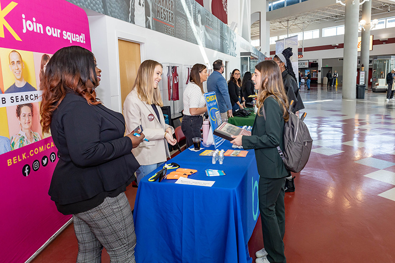 Belk's three recruiters speak with a student about potential jobs and internships at the company during the Experience Expo.