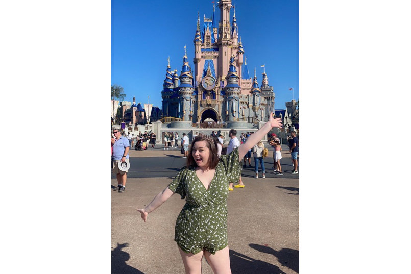 Emilie Miller poses in front of the castle at Magic Kingdom in Disney World.