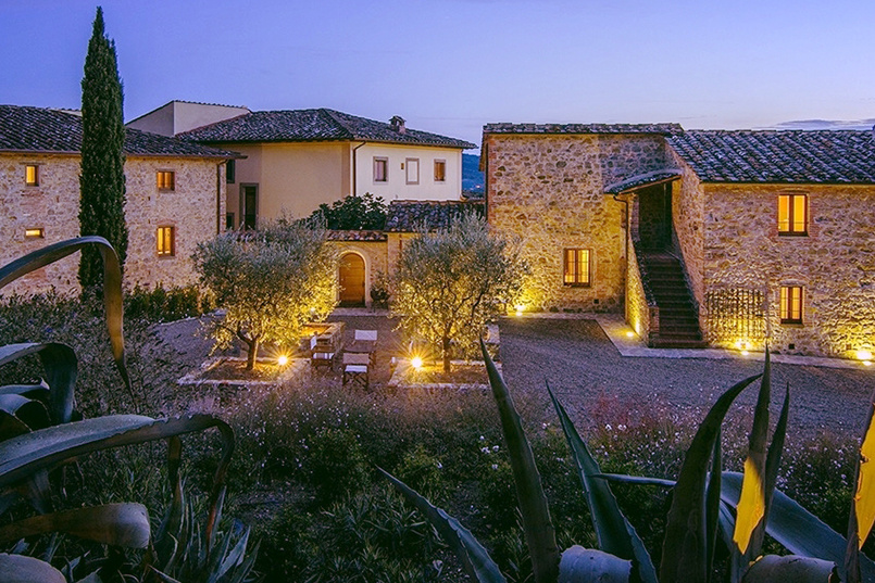 An outside view of a Tuscan villa at dusk.