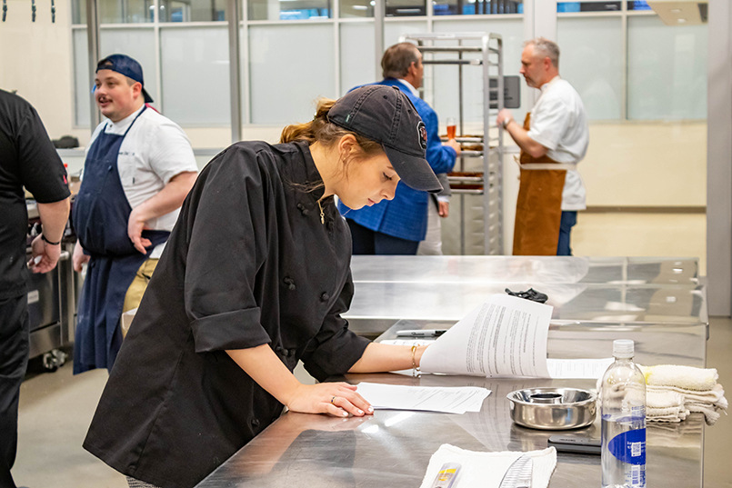 A student reads instructions inside the Marriott Lab's commercial kitchen.