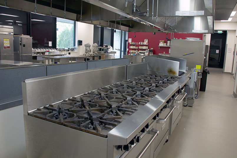 Inside look at the J. Willard and Alice S. Marriott Foundation Culinary Laboratory showcasing a large row of stoves and ovens.