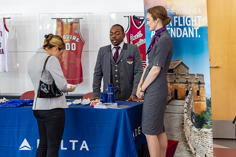 Two flight attendants from Delta Airlines speak with HRSM students at Experience Expo.
