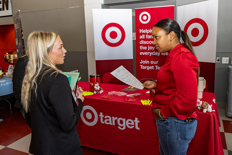 A member of Target looks at a resume while visiting with an HRSM student at Experience Expo.