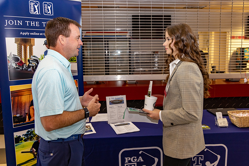 A representative from the TPC at Sawgrass speaks with an HRSM student at Experience Expo.
