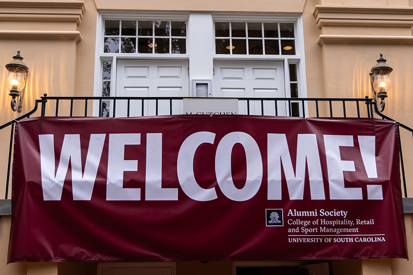 A large banner stating "Welcome!" hangs down from the top of the staircase of the front entrance to McCutchen House.