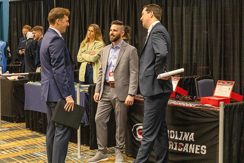 A student speaks with members of the Carolina Hurricanes at a career fair