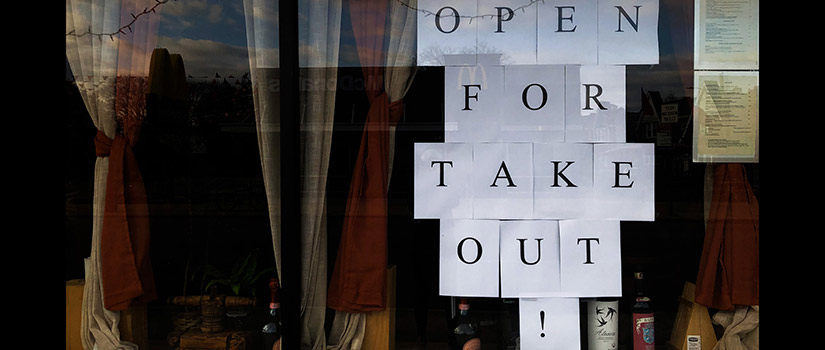 Restaurant with menus and window sign that says, "Open for Take Out!"