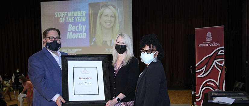 Becky Moran receives the Staff Member of the Year award from Interim Dean Matt Brown and committee chair Stephanie Richards at the 2021 HRSM Faculty-Staff Awards Ceremony