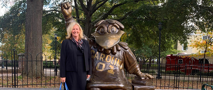 Lori Pennington-Gray, the new director for the Richardson Family SmartState Center of Economic Excellence in Tourism and Economic Development, stands beside the bronze statue of Cocky.