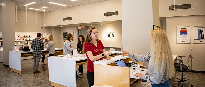 UofSC student employees work with Gamecock iHub Apple Store customers. One customer is purchasing an Apple product.
