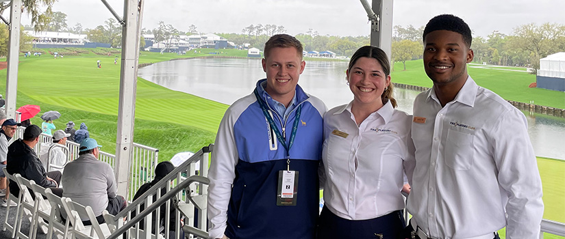 Three students smile for the camera while working the 2022 Players Championship.