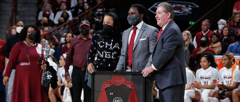 Jonathan "Hamp" Hampton stands on the basketball court with Ray Tanner who presents him with a framed Gamecock jersey.