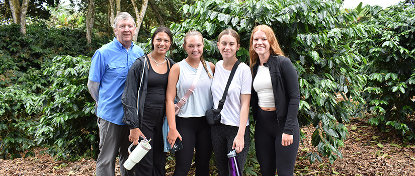 Kevin Ayres poses with four students outside Ranti Coffee