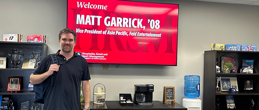Matt Garrick stands in front of a digital welcome screen displaying his name and title as Vice President of Asia Pacific for Feld Entertainment.